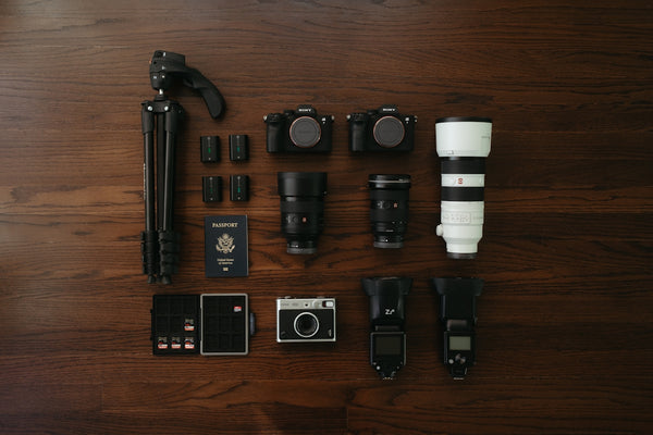 Photographer's equipment arranged neatly on a wooden table.