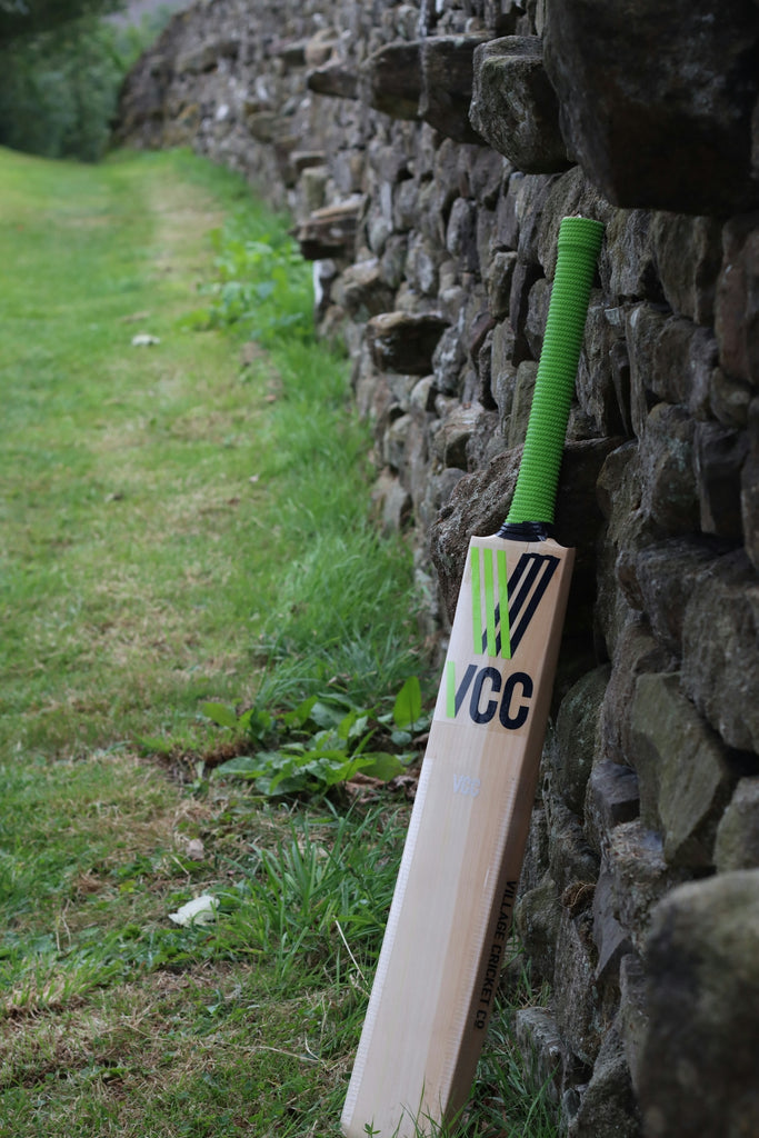 Cricket bat leaning against a stone wall