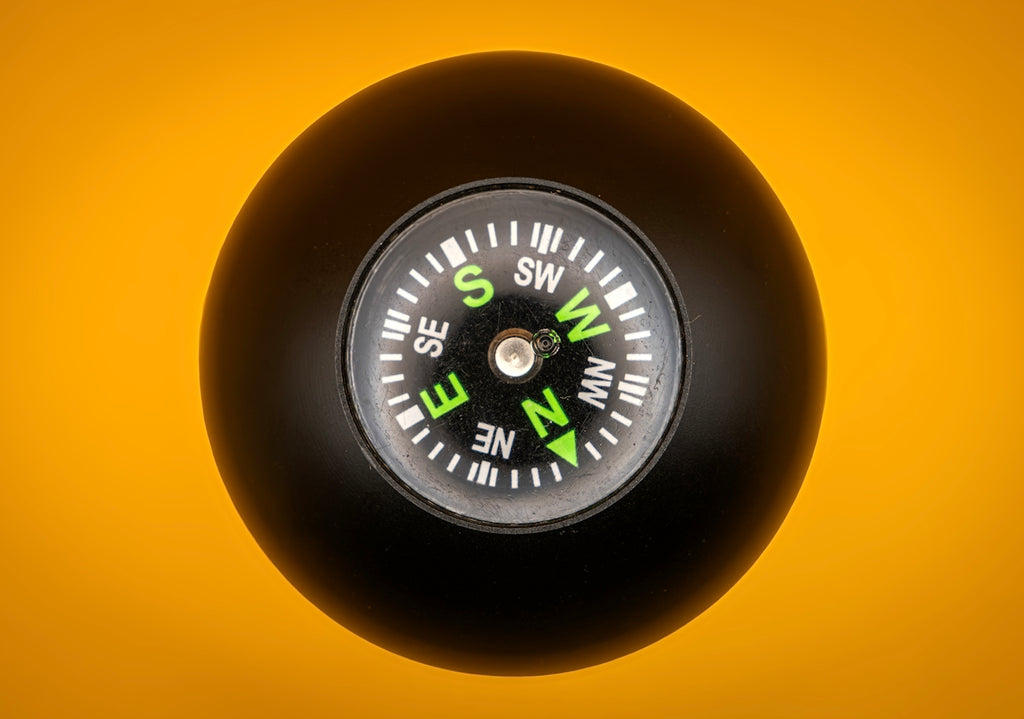 Black compass on a yellow background