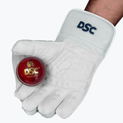 DSC Intense Pro adult wicketkeeping glove holding a red cricket ball in the catching palm